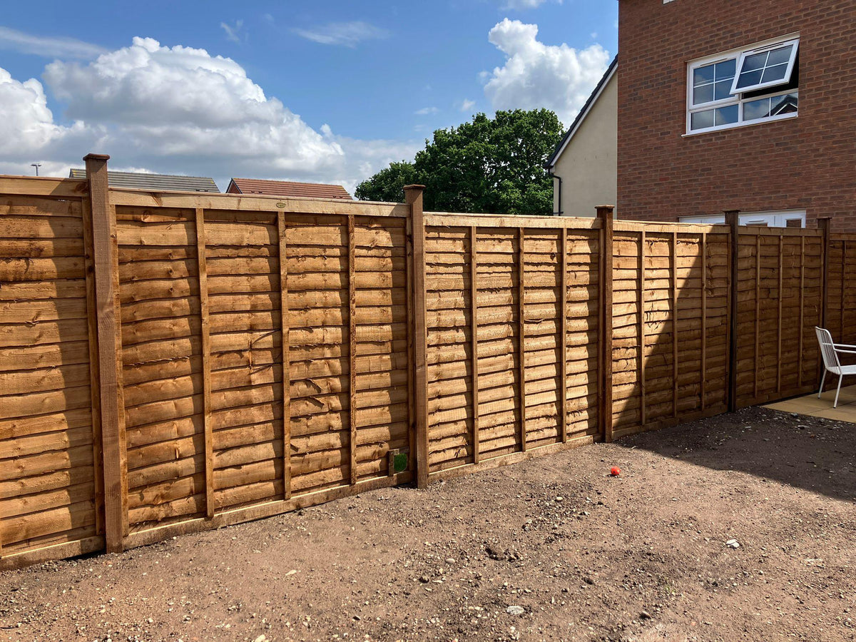 Pressure treated feather edge fencing installed along a driveway