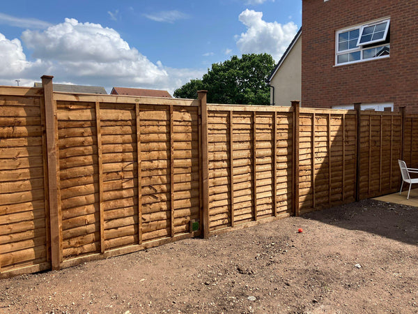 Pressure treated feather edge fencing installed along a driveway