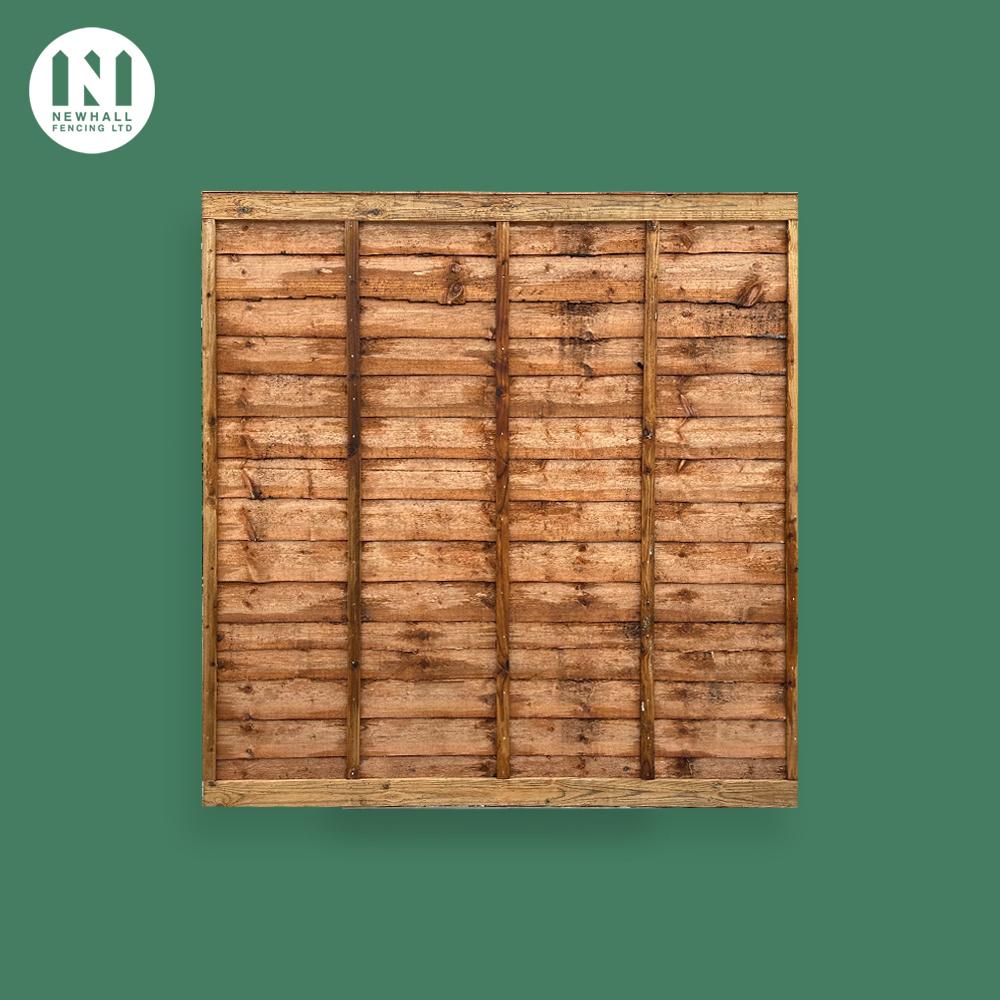 Pressure treated waney lap fence panel on a green background
