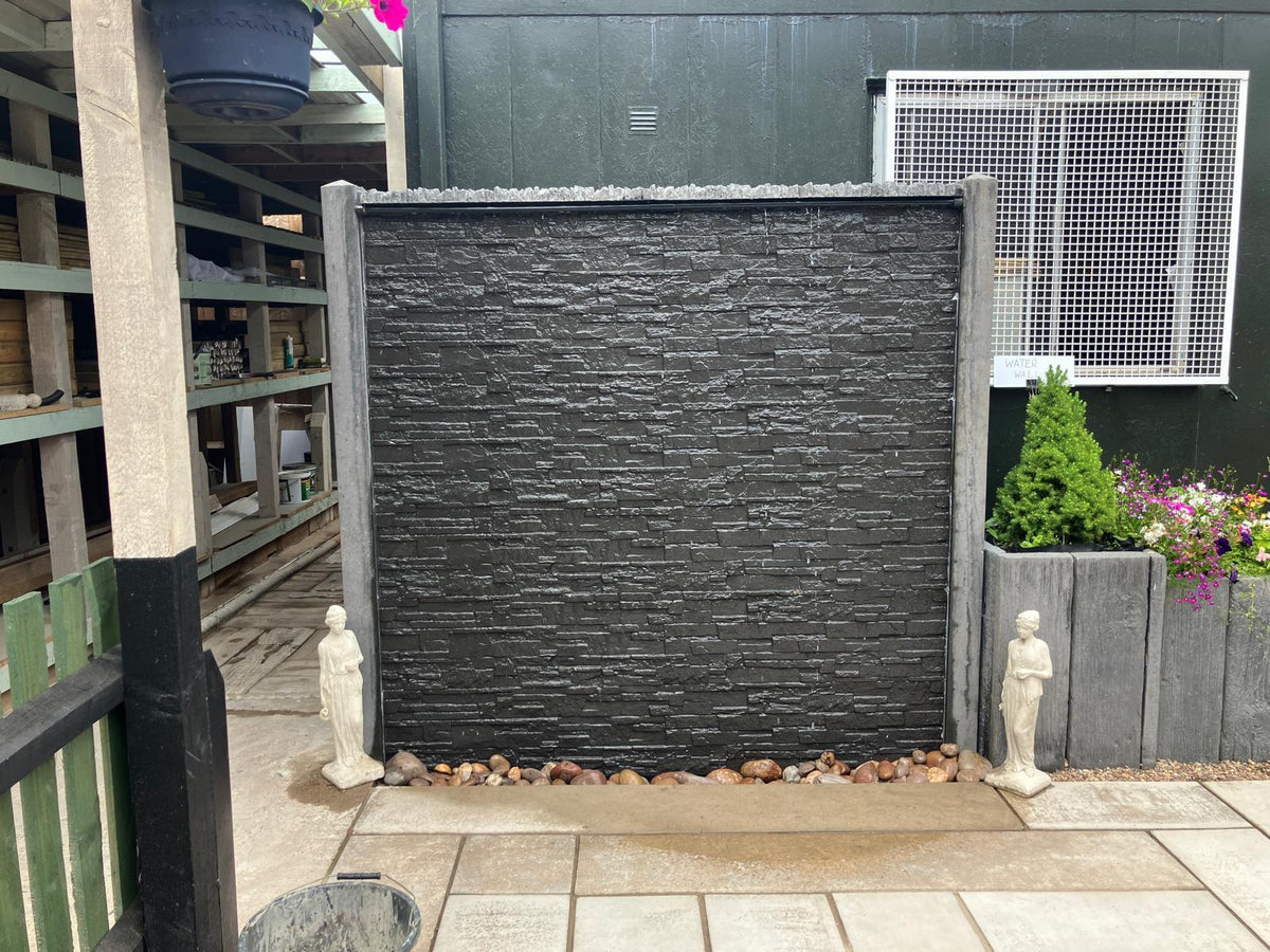 Slate effect concrete water wall feature set up in a garden