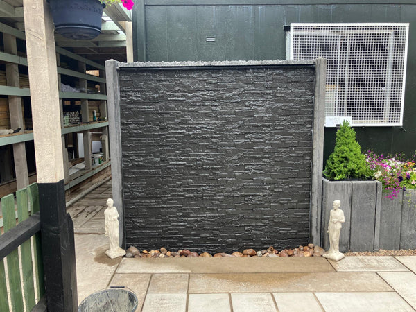 Slate effect concrete water wall feature set up in a garden